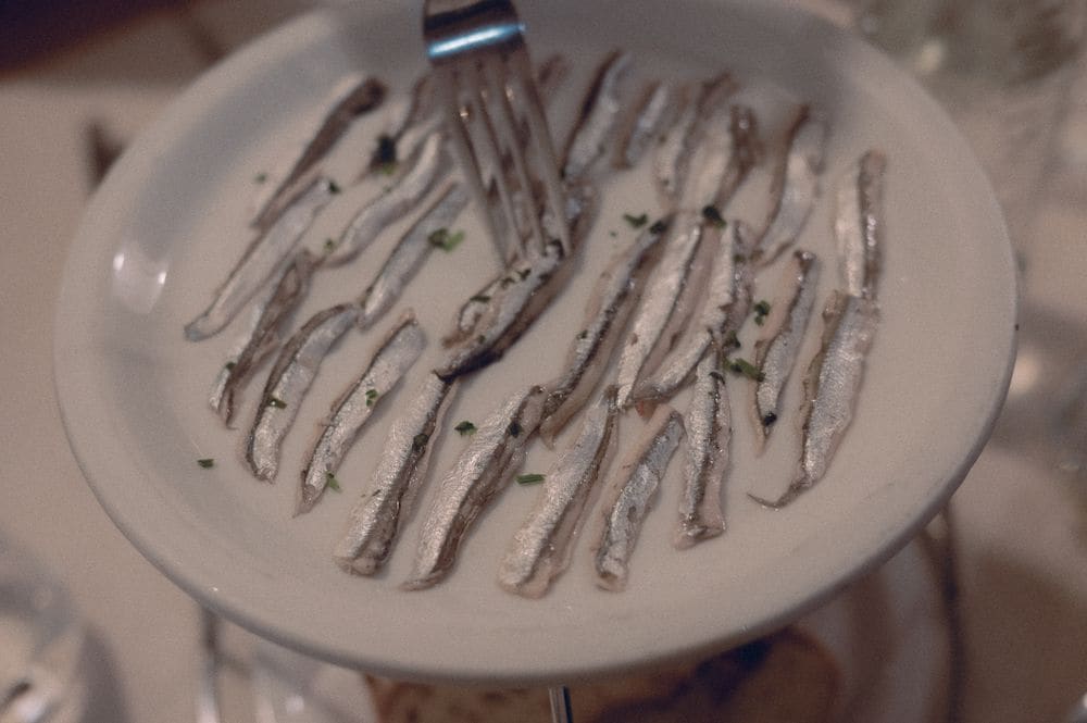 Alici marinate su un piatto bianco.